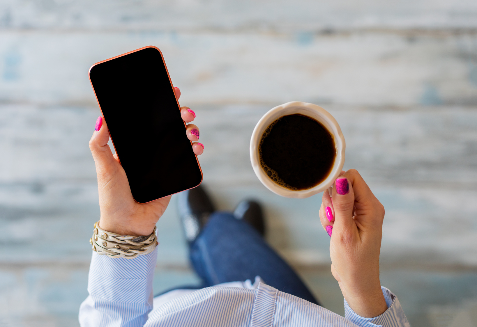 Woman Using Mobile Phone and Holding Cup of Coffee